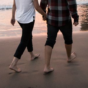 couple walking on beach holding hands